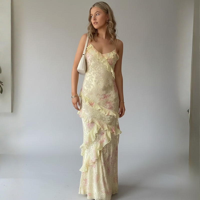 Woman wearing a floral one-shoulder dress against a plain background