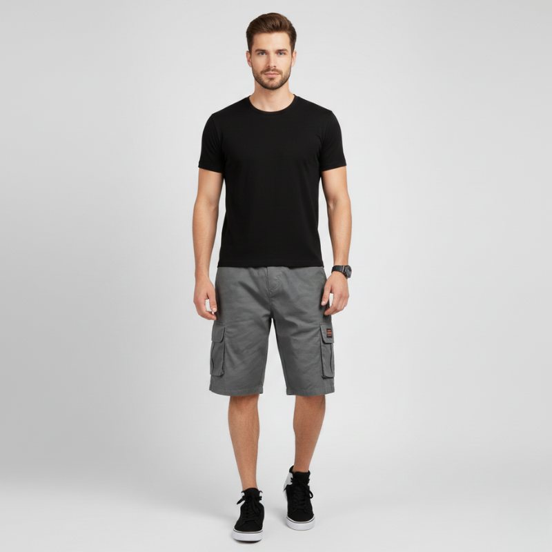 Man wearing a black t-shirt and gray cargo shorts on a light gray background