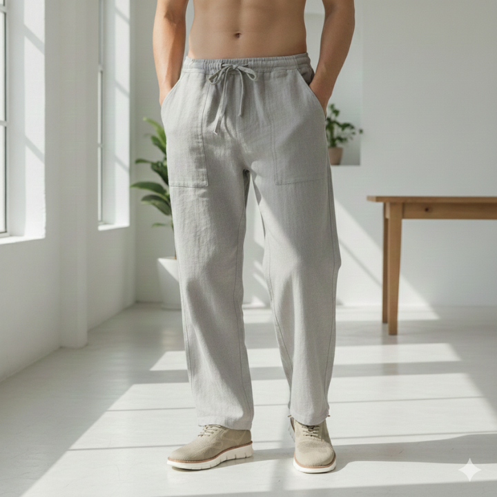 Person wearing light gray pants standing in a bright, minimalistic room.