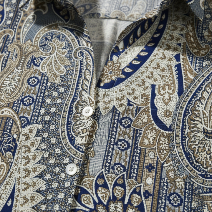 Close-up of a patterned shirt with intricate designs in blue, beige, and white.
