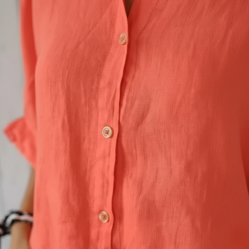 Close-up of a coral-colored button-up shirt with a blurred background