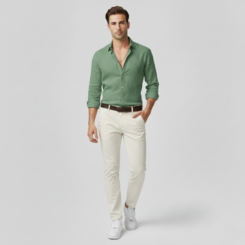 Man wearing a green shirt and white pants on a light gray background