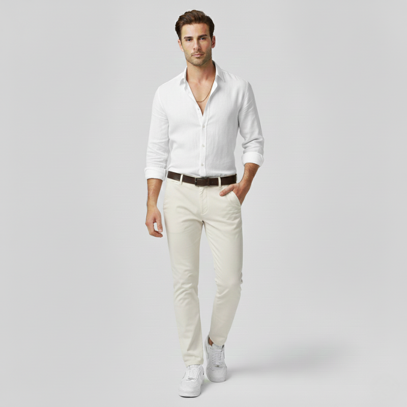 Man wearing a white shirt, beige pants, and white sneakers on a light gray background