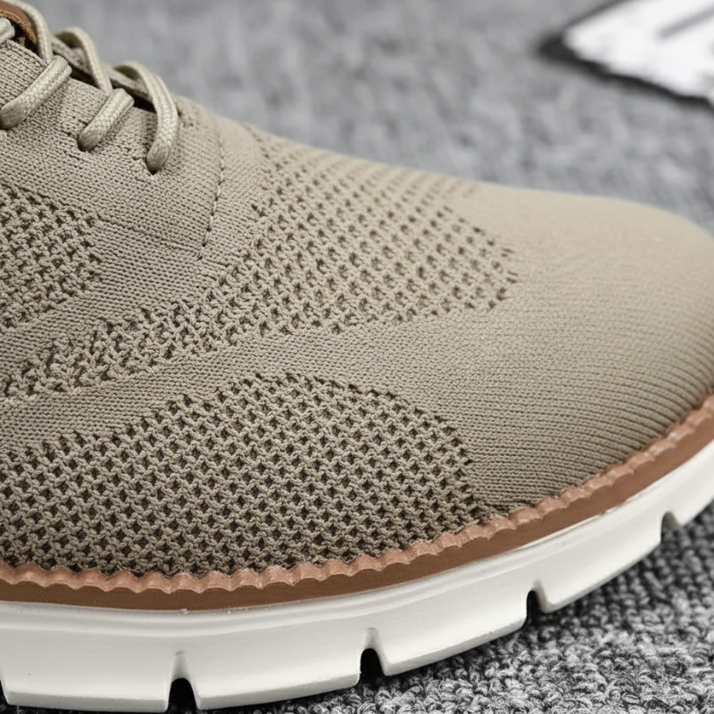 Close-up of a beige sneaker with a textured pattern on a gray surface