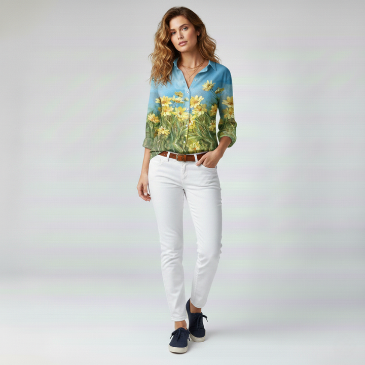 Woman wearing a floral shirt and white pants on a plain background