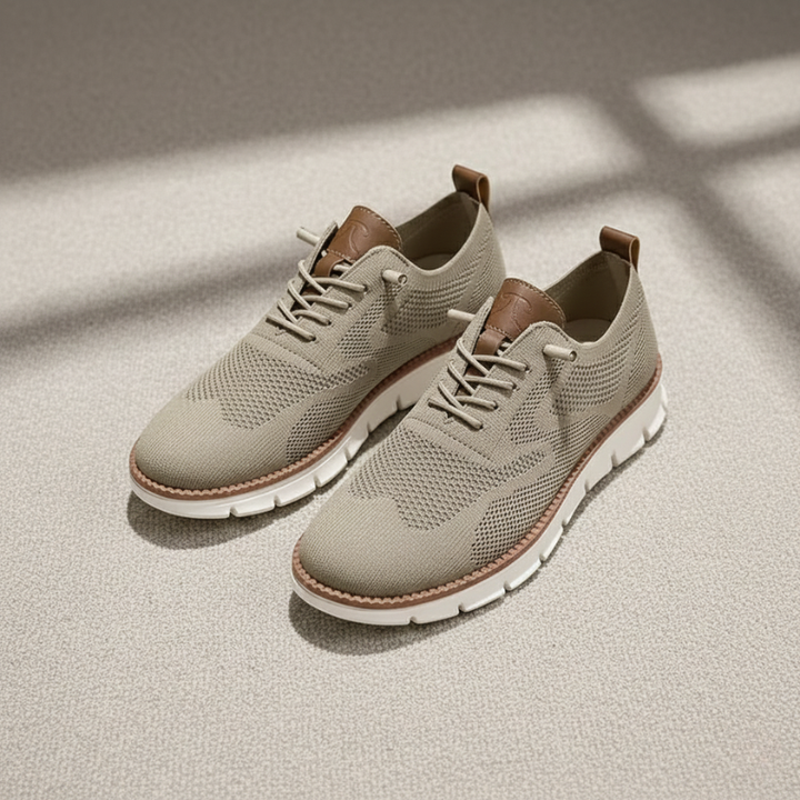 Pair of beige sneakers with brown accents on a light surface