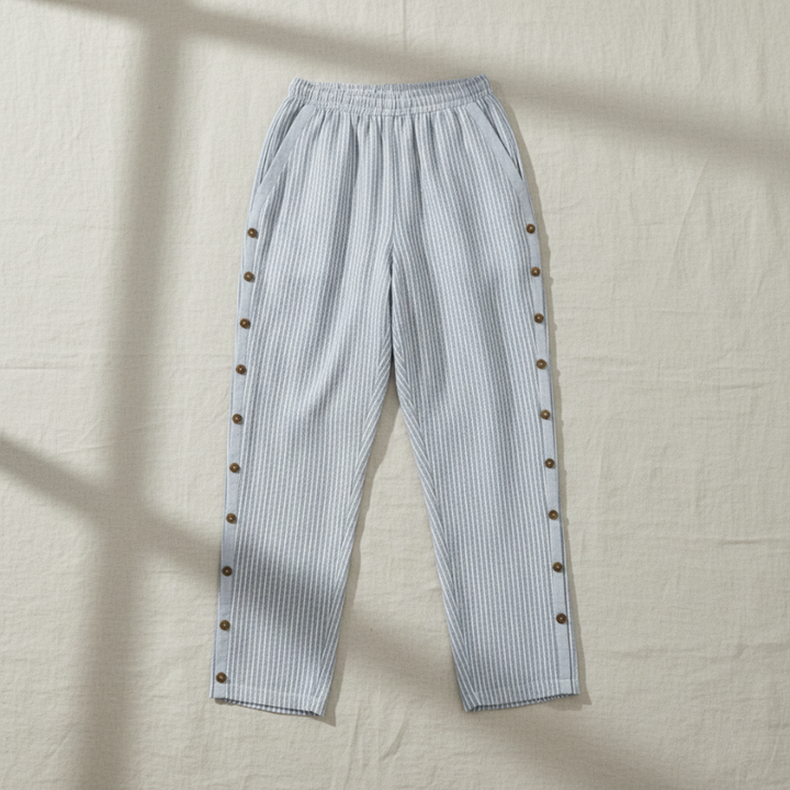 Light blue striped pants with button details on a beige background