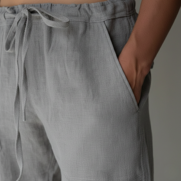 Gray pants with a drawstring waist on a neutral background