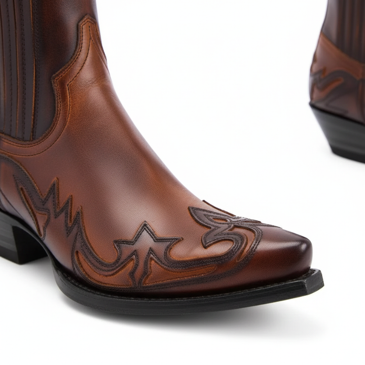 Brown cowboy boot with intricate stitching on a white background