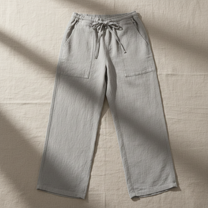 Light gray pants with drawstring on a beige fabric background
