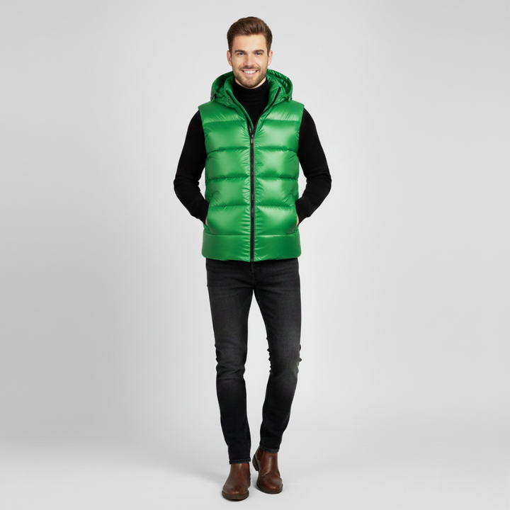 Man wearing a green puffer vest on a light gray background