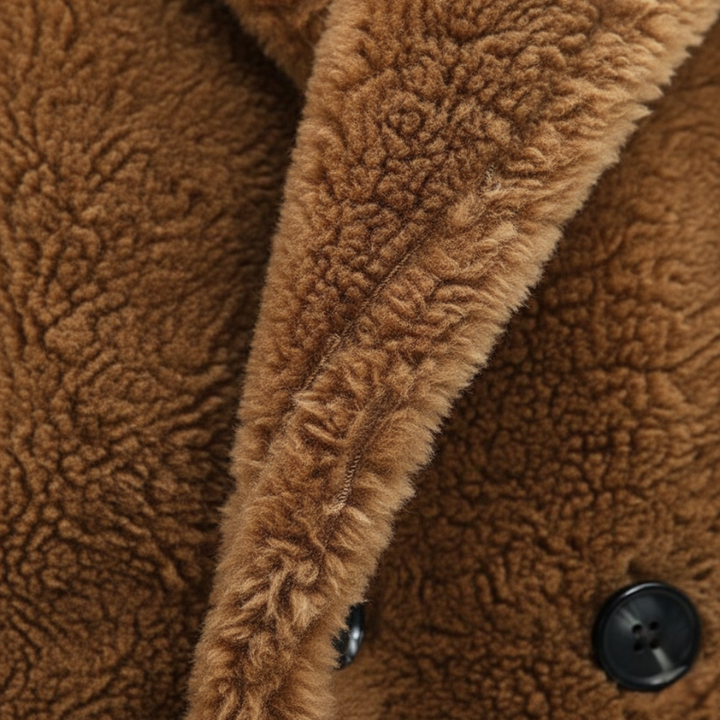 Close-up of a brown sherpa coat showing plush fleece texture, wide collar, and black button detail.