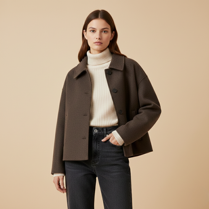 Woman wearing a brown coat over a white sweater on a beige background