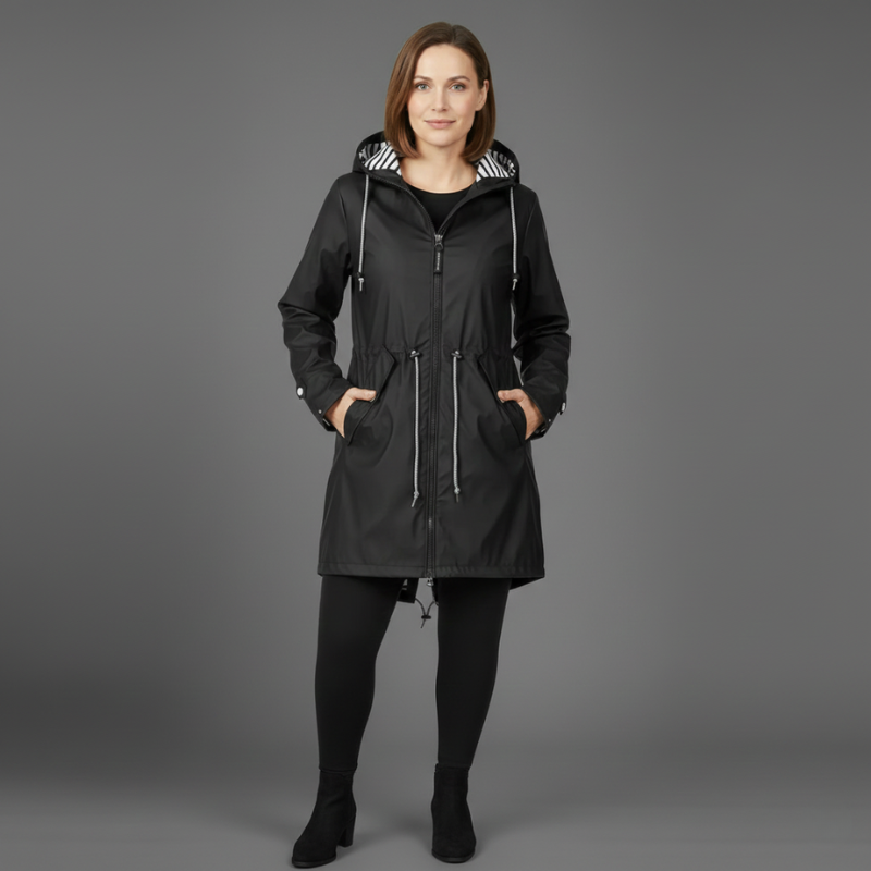 Female model wearing a black winter coat with hood in studio lighting.