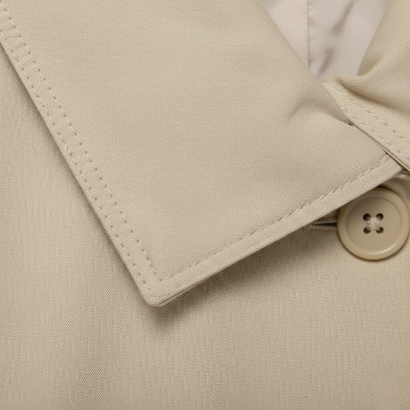 Close-up of a beige fabric with a button on a coat