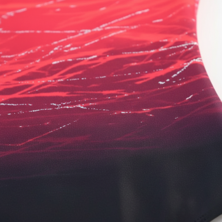 Close-up of pink gradient swimsuit fabric showing smooth texture and printed pattern.