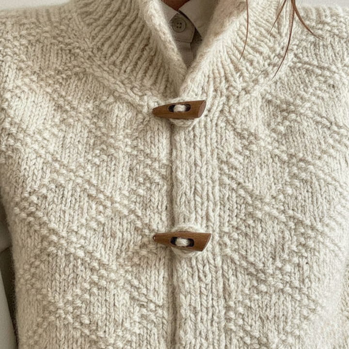 Close-up of a textured beige sweater with wooden buttons.