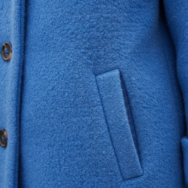 Close-up of a blue textured fabric with a pocket detail