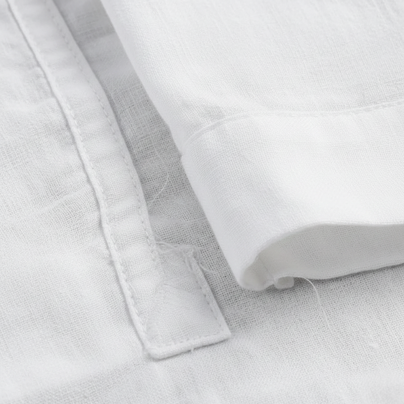 Close-up shot of breathable white linen fabric showing weave texture and soft lightweight material.