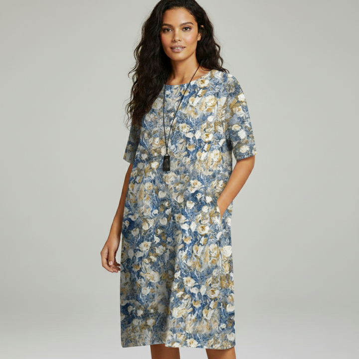 Floral midi dress hanging on a wooden hanger showing pattern placement and flowy fabric.