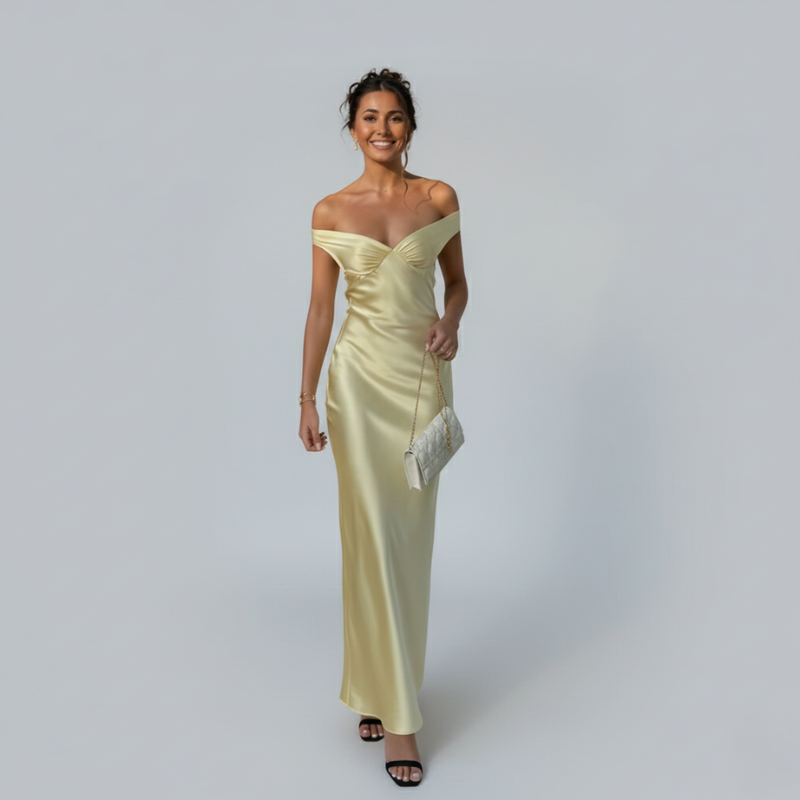 Woman wearing a light yellow off-shoulder gown against a plain background