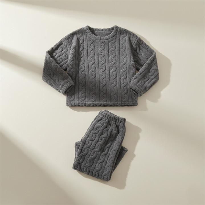 Flatlay of a gray fleece lounge top and pants folded neatly on a neutral surface.