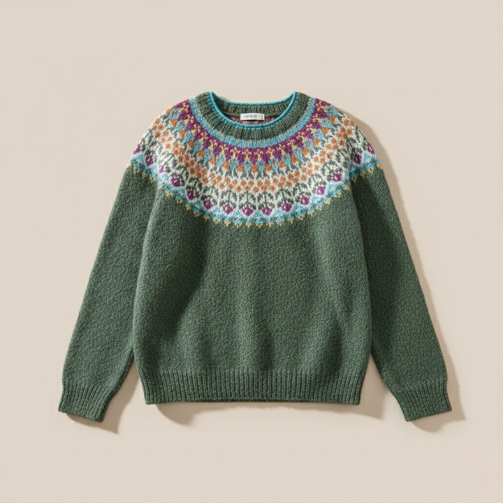 Flatlay of a green knit sweater with a colorful round-yoke pattern placed on a beige surface.