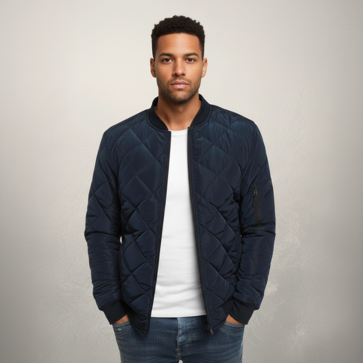 Model trägt eine navyblaue Steppjacke kombiniert mit Jeans in einem hellen Innenraum mit natürlichem Lichteinfall.