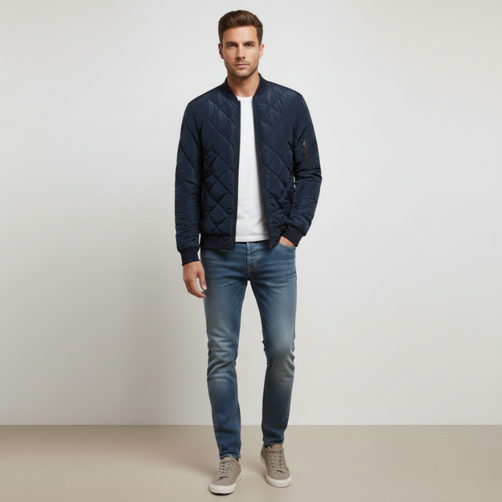 Model trägt eine navyblaue Steppjacke mit Reißverschluss, klassischem Kragen und gerader Passform in einer neutralen Studioszene.