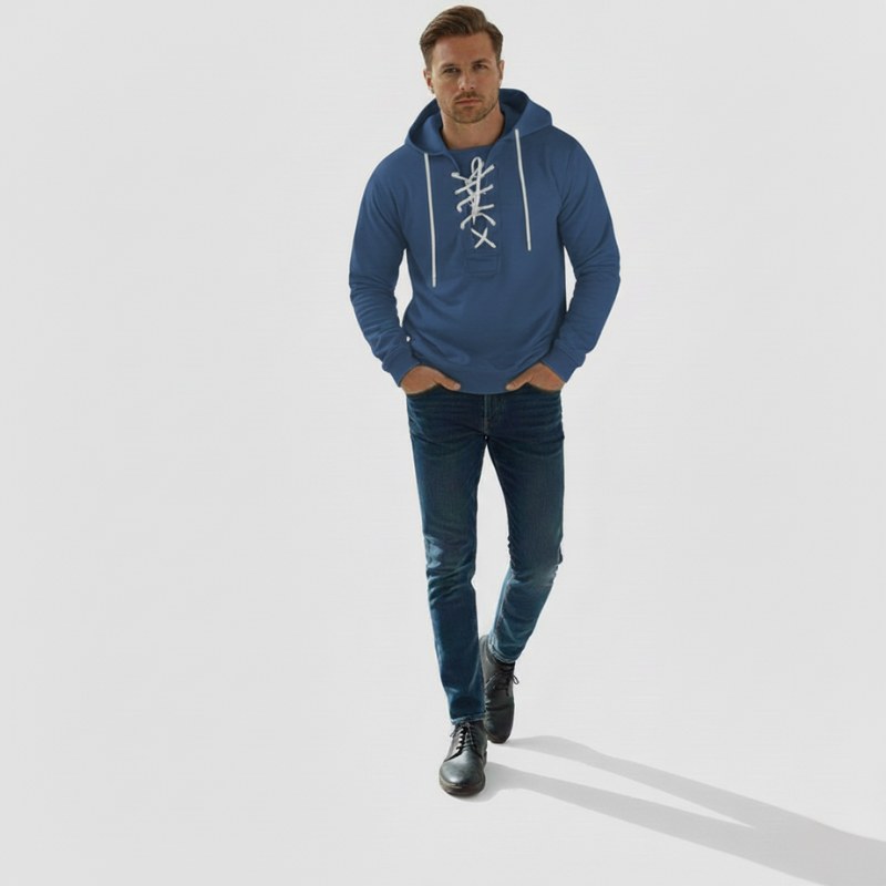 Blue hoodie with decorative lacing, relaxed silhouette and ribbed cuffs in a bright studio scene.