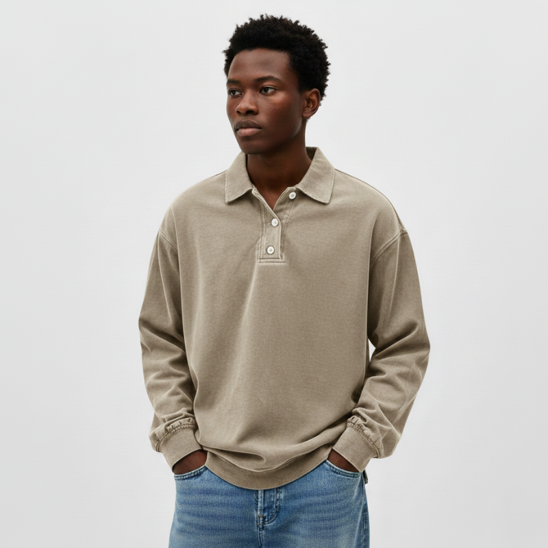 Man wearing a beige knit polo sweatshirt indoors, styled with light pants for a clean casual outfit.