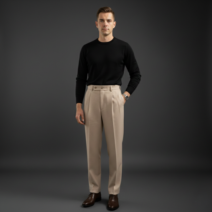 Male model in beige tailored dress pants styled with a black top in a clean studio environment.