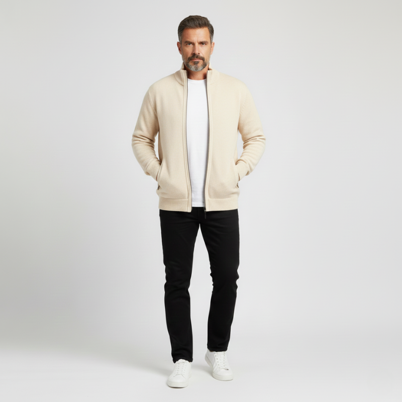 Man wearing a beige cardigan, white t-shirt, black pants, and white sneakers on a light gray background.