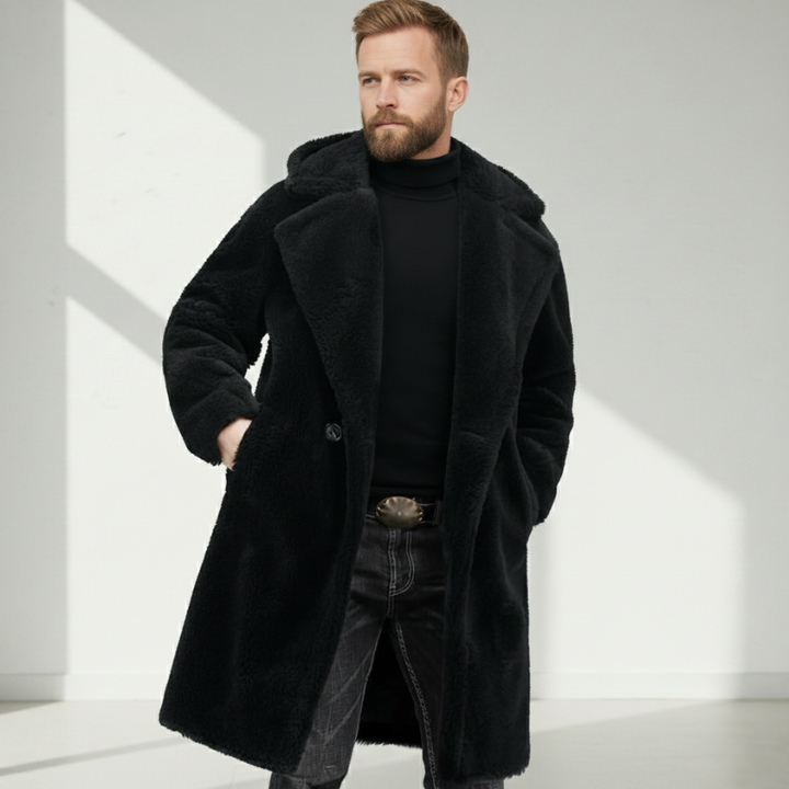 Side-view shot of a man wearing a black long overcoat styled with layered winter clothing.