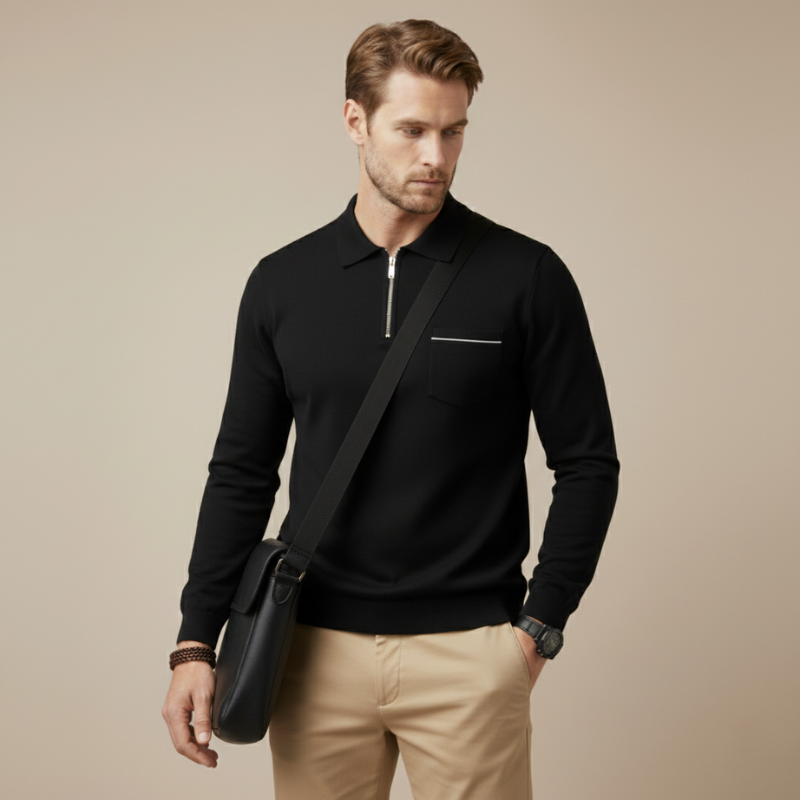 Man in a black long-sleeve quarter-zip polo shirt styled with light pants in a studio environment.