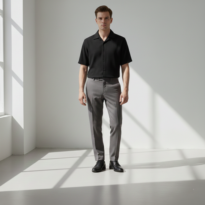 Male model in a black short-sleeve button-up shirt with a clean minimalist design.