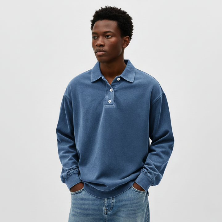 Man wearing a blue long-sleeve knit polo sweatshirt with a relaxed fit and soft texture in studio lighting.
