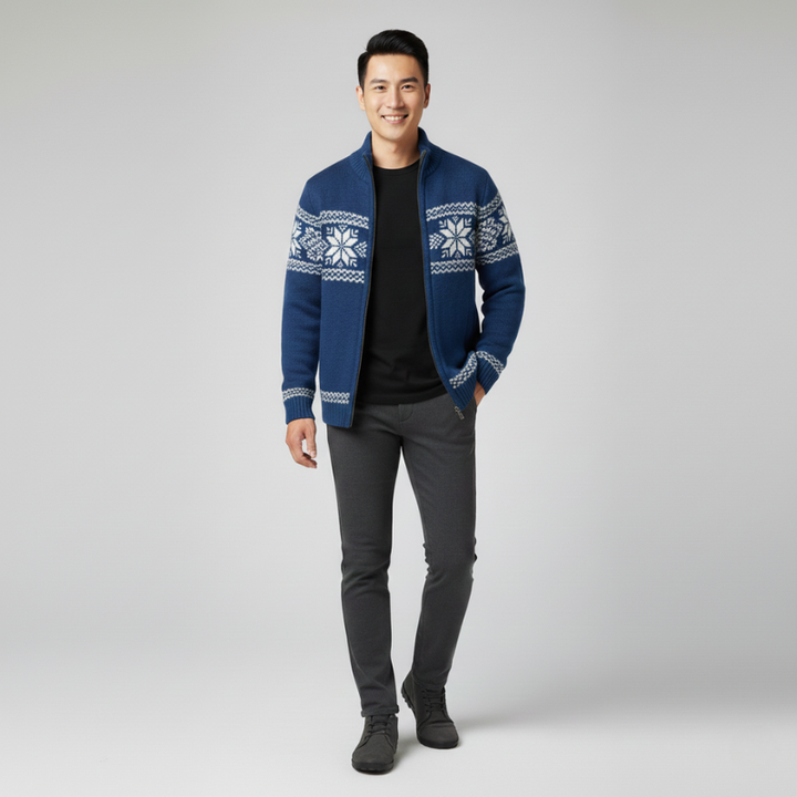 Man wearing a blue knit zip-front sweater paired with dark trousers in studio lighting.