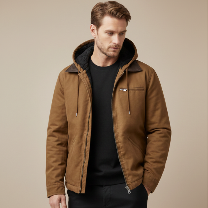 Man wearing a brown canvas jacket with a hood, styled casually with a black inner layer.