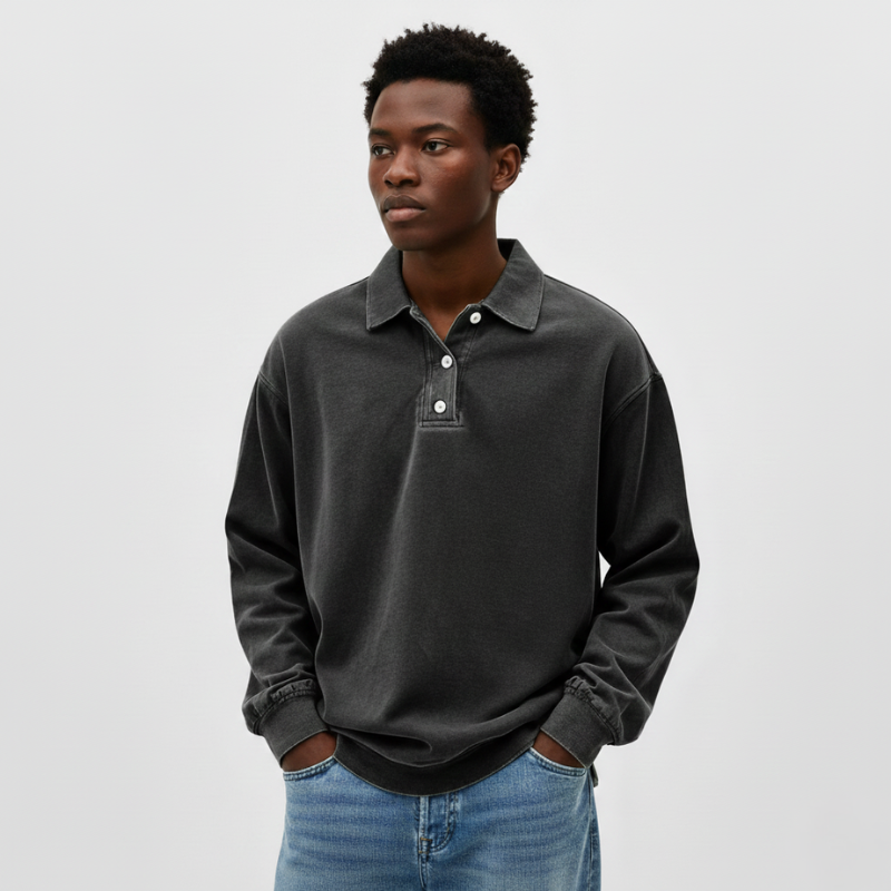 Man standing in a dark gray knit polo sweatshirt with a relaxed silhouette and soft feel.