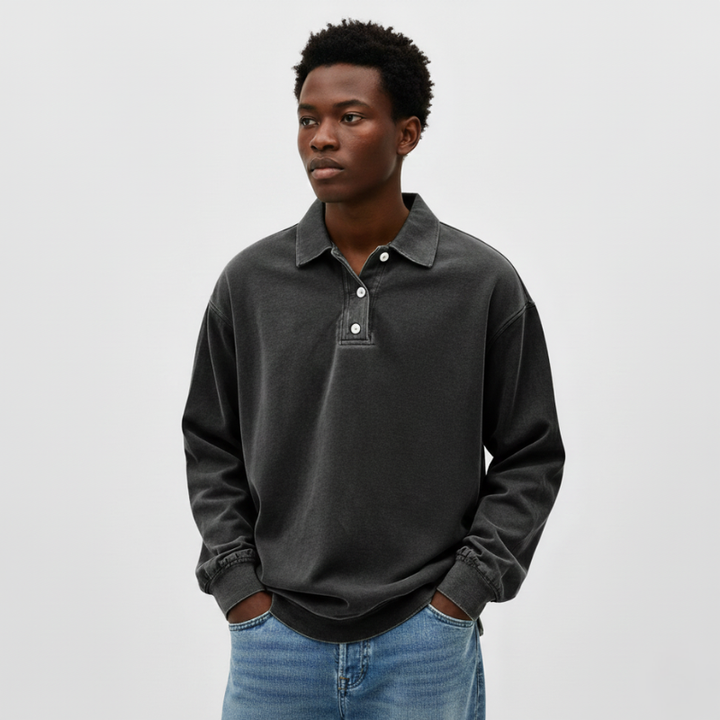 Man standing in a dark gray knit polo sweatshirt with a relaxed silhouette and soft feel.