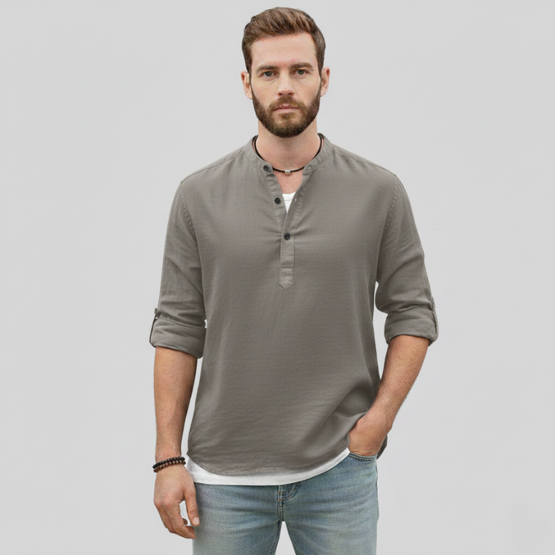 Man wearing a gray linen long-sleeve casual shirt with a relaxed fit in soft indoor lighting.