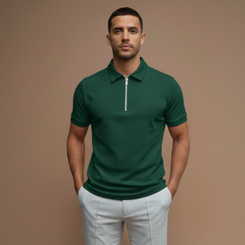 Male model in a green short-sleeve polo shirt styled casually with light pants in soft indoor lighting.