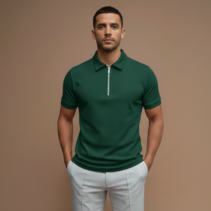 Male model in a green short-sleeve polo shirt styled casually with light pants in soft indoor lighting.
