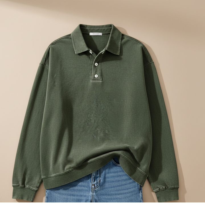 Man wearing a green knit polo sweatshirt styled casually with denim jeans in a soft indoor setting.