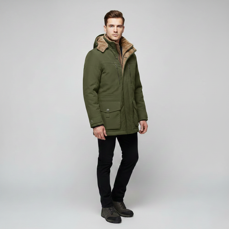 Man standing in a green winter jacket with a hood, warm padding, and functional pockets.