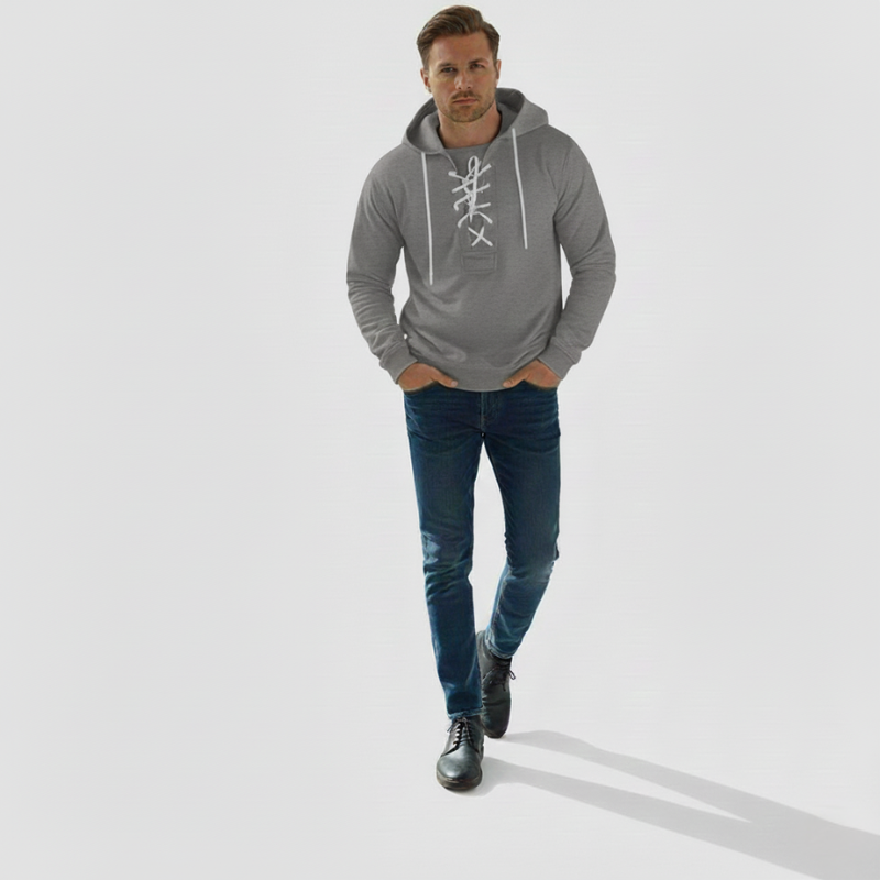 The model wears a grey hoodie with drawstring at the neckline, a loose fit and a sporty look in the studio.