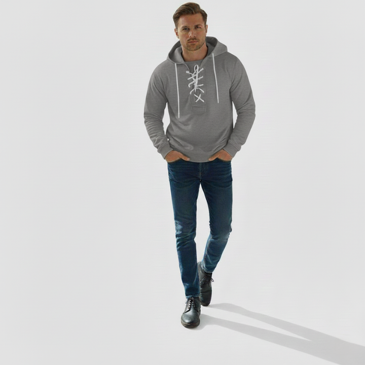 The model wears a grey hoodie with drawstring at the neckline, a loose fit and a sporty look in the studio.