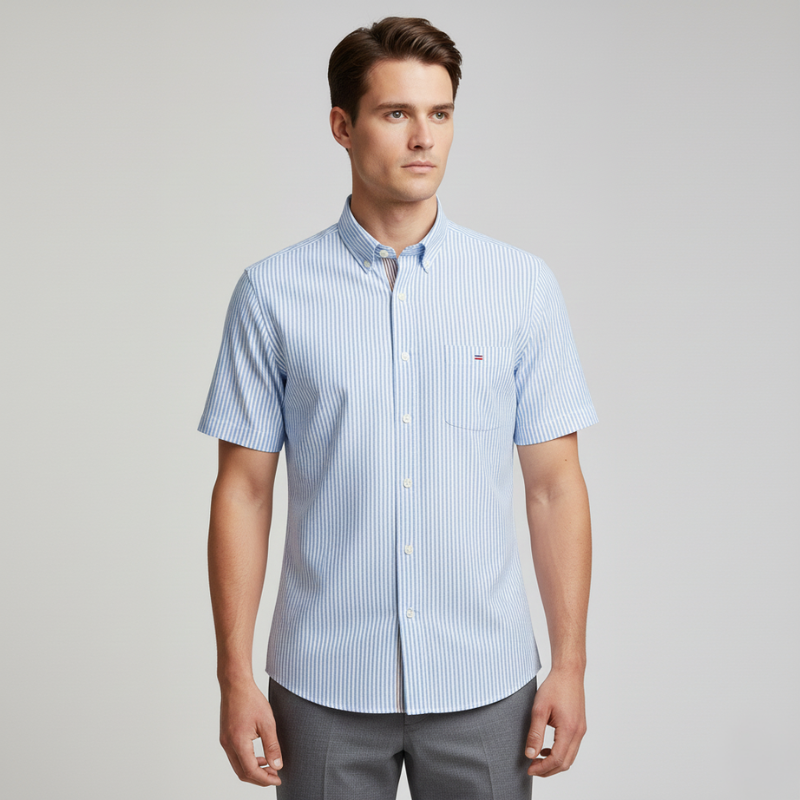 Male model in a light blue short-sleeve button-up shirt with a relaxed modern fit.