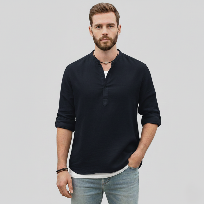 Man wearing a navy linen long-sleeve shirt styled casually with dark trousers.
